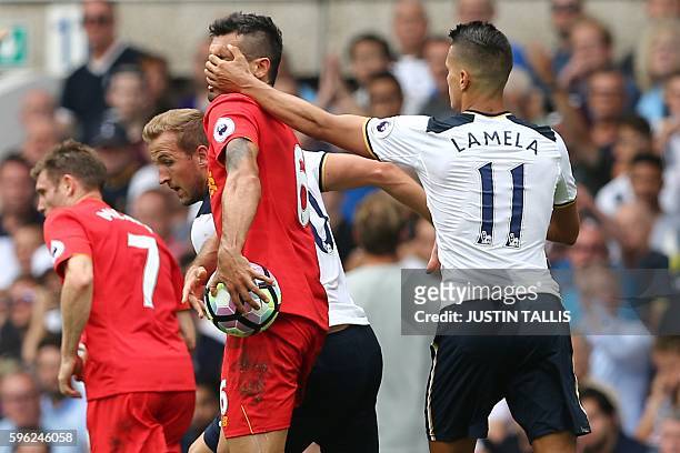 Tottenham Hotspur's Argentinian midfielder Erik Lamela grabs Liverpool's Croatian defender Dejan Lovren in the face during the English Premier League...
