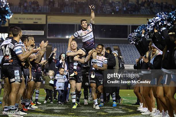 Michael Ennis of the Sharks is chaired off by team mates during the round 25 NRL match between the Cronulla Sharks and the Sydney Roosters at Shark...