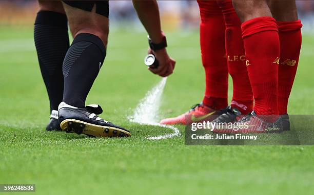 Referee Booby Madley uses his vanishing spray during the Premier League match between Tottenham Hotspur and Liverpool at White Hart Lane on August...