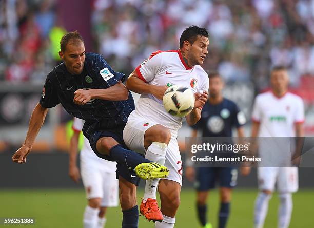 Raul Bobadilla of FC Augsburg challenges Bas Dost of VfL Wolfsburg during the Bundesliga match between FC Augsburg and VfL Wolfsburg at WWK Arena on...