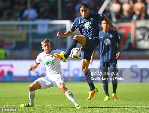 Alfred Finnbogason of FC Augsburg challenges Ricardo Rodriguez of VfL Wolfsburg during the Bundesliga match between FC Augsburg and VfL Wolfsburg at...