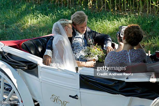 Bridal pair Samuel Koch and Sarah Elena Timpe get photos taken while they ride a carriage after the wedding at the local church to go to their party...