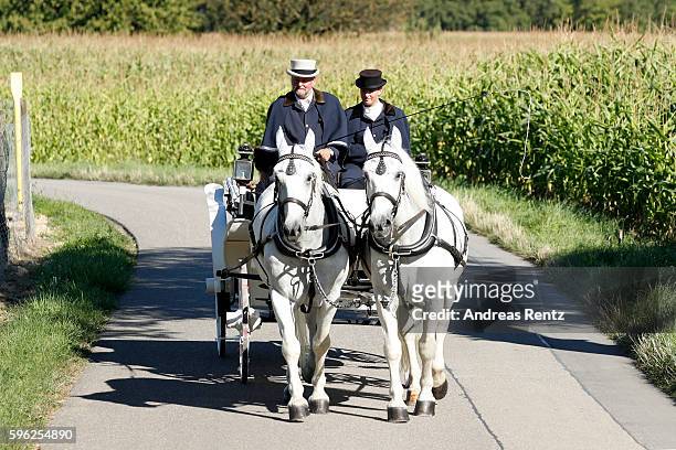 Bridal pair Samuel Koch and Sarah Elena Timpe ride a carriage after the wedding at the local church to go to their party on August 27, 2016 near...