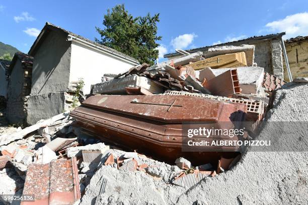 Picture taken on August 27, 2016 shows damaged coffins and rubble at the cemetery of Sant'Angelo, 15km from the Italian village of Amatrice, three...