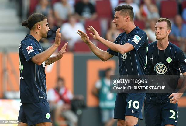 Wolfsburg's Swiss defender Ricardo Rodriguez, Wolfsburg's midfielder Julian Draxler and Wolfsburg's midfielder Maximilian Arnold celebrate after...