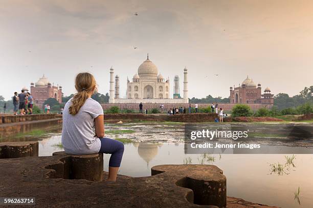 a young girl watching the taj mahal at sunset. - agra fotografías e imágenes de stock
