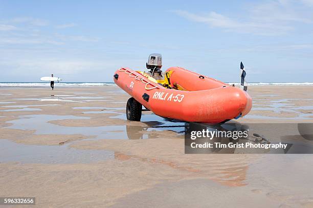 inflatable orange lifeboat resting on a trailor on the beach - barco salvavidas fotografías e imágenes de stock