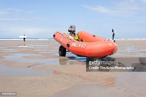 inflatable orange lifeboat resting on a trailor on the beach - 救命ボート ストックフォトと画像