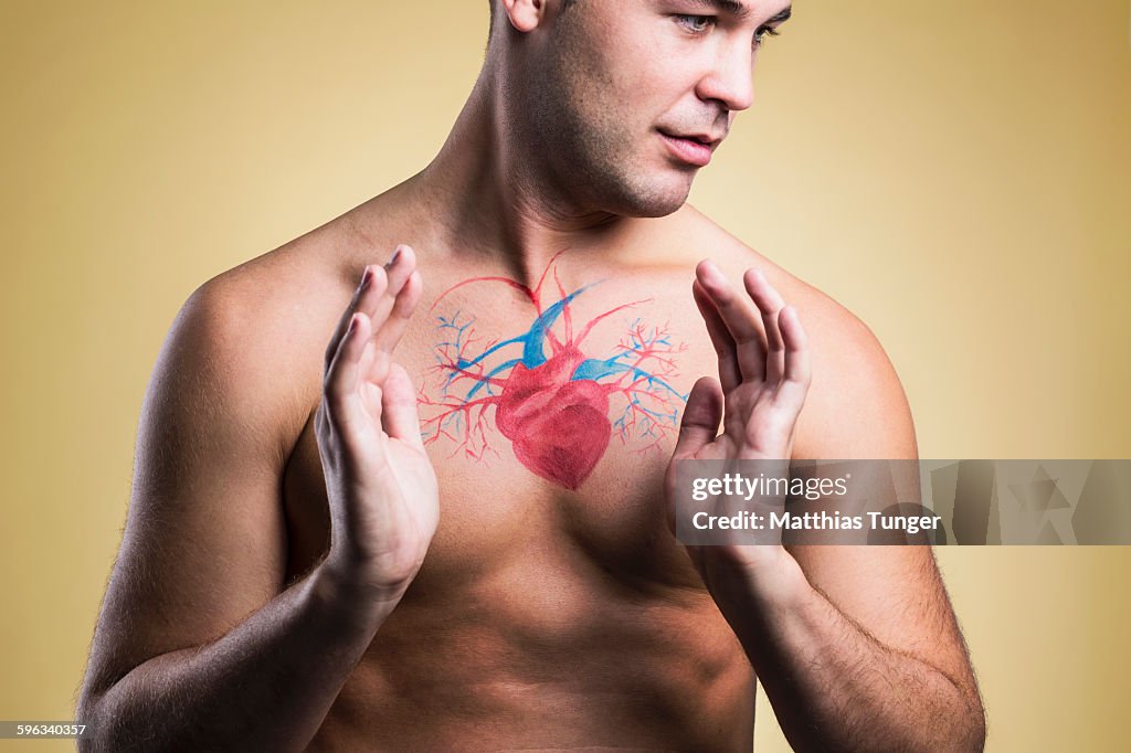 Man with hands around diagram of his heart