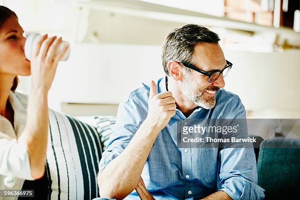 laughing businessman in meeting with colleagues - soddisfazione foto e immagini stock