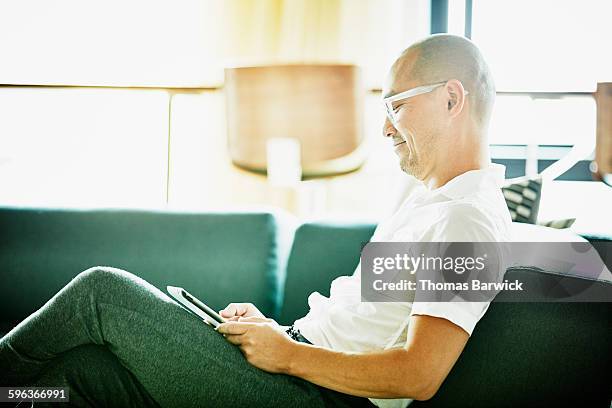 smiling businessman working on digital tablet - ein tag im leben stock-fotos und bilder