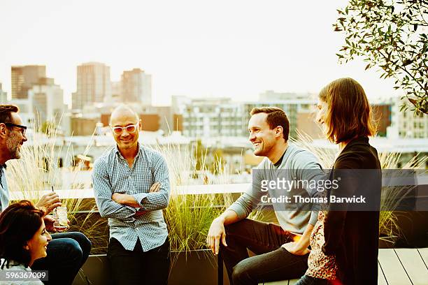 colleagues sharing drinks on office terrace - happy asian woman bright office stock-fotos und bilder