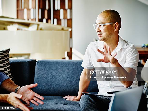 businessman discussing project with coworker - candid office stock-fotos und bilder
