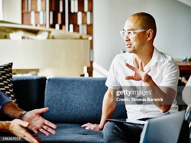 businessman discussing project with coworker - een dag uit het leven serie stockfoto's en -beelden