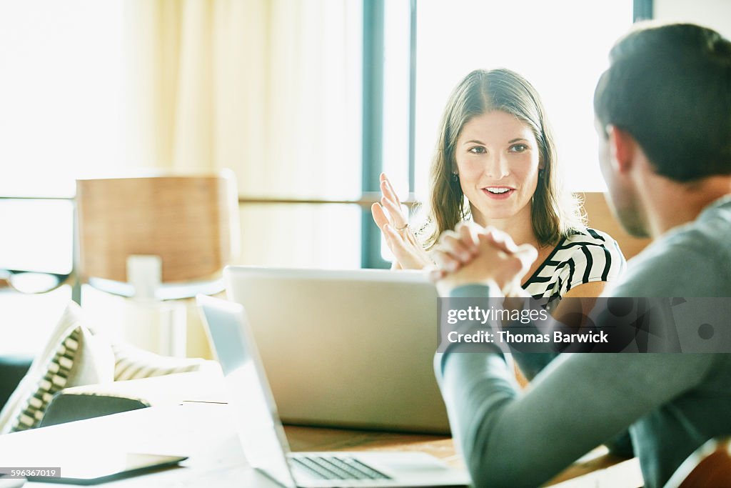 Smiling businesswoman in discussion with colleague