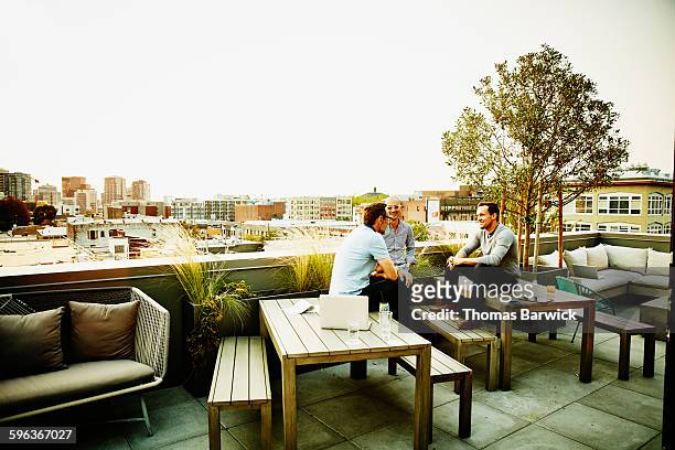 colleagues having meeting on office terrace - business man modern city photos et images de collection