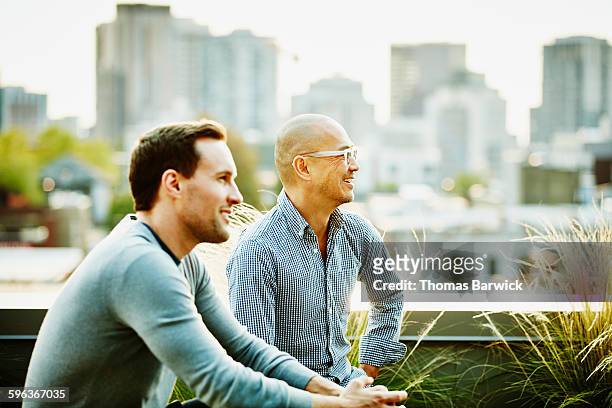 businessmen in informal meeting on office terrace - city life authentic stock pictures, royalty-free photos & images