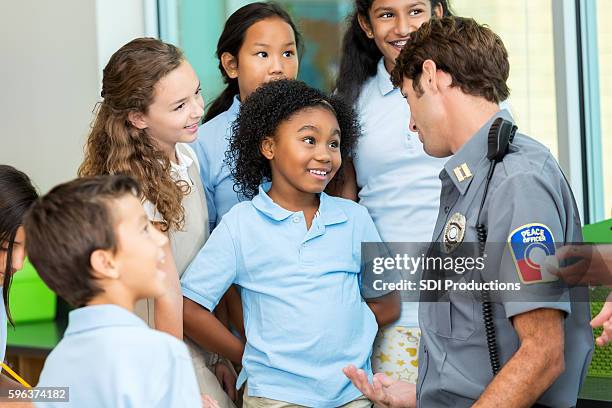 elementary school student asks policeman a question - charter school stock pictures, royalty-free photos & images