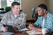 Mature military officer talking to man in recruitment office