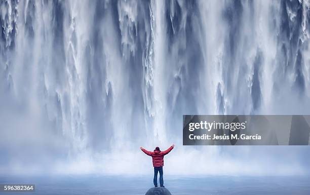 man and waterfall - catarata fotografías e imágenes de stock