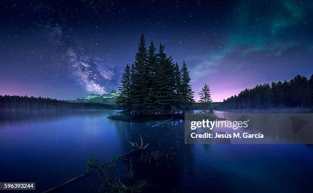 milky way and aurora borealis at two jack lake - noorderlicht sterren stockfoto's en -beelden