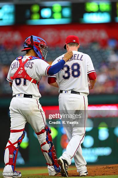 Robinson Chirinos of the Texas Rangers calls a time out to talk with Lucas Harrell in in the second inning against the Oakland Athletics at Globe...