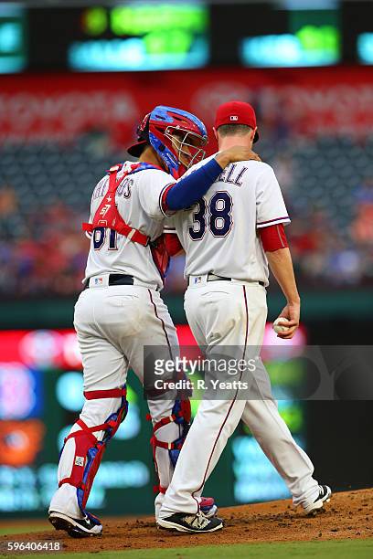Robinson Chirinos of the Texas Rangers calls a time out to talk with Lucas Harrell in in the second inning against the Oakland Athletics at Globe...