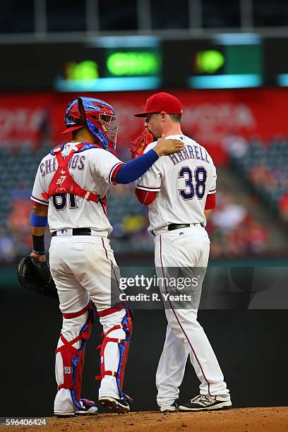 Robinson Chirinos of the Texas Rangers calls a time out to talk with Lucas Harrell in in the second inning against the Oakland Athletics at Globe...