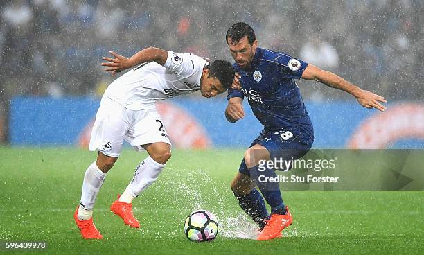 Jefferson Montero of Swansea City attempts to take the ball past Christian Fuchs of Leicester City during the Premier League match between Leicester...