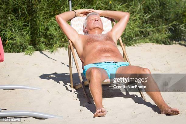 Man relaxes in the sun during a hot summer's day in Bydgoszcz, Polan on August 27 2016. After several months of humid but relatively cold weather the...