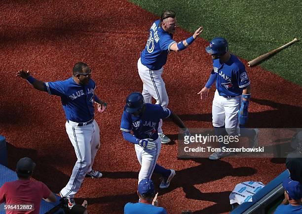 Melvin Upton Jr. #7 of the Toronto Blue Jays is congratulated by Edwin Encarnacion after hitting a two-run inside-the-park home run as Josh Donaldson...