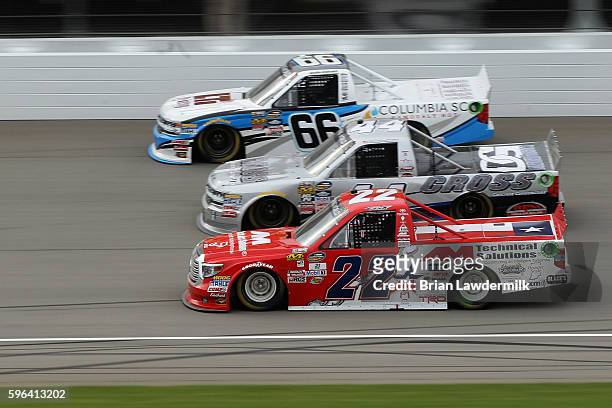 Austin Wayne Self, driver of the AM Technical Solutions Toyota, races Tommy Joe Martins, driver of the Cross Concrete Construction Chevrolet, and...