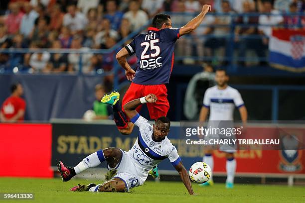 Caen's French midfielder Julien Feret jumps above with Bastia's French midfielder Lenny Nangis during the French L1 football match between Caen and...