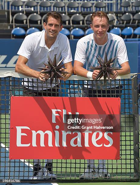 Guillermo Garcia-Lopez of Spain, left, and partner Henri Kontinen of Finland hold the trophies after their win over Andre Begemann of Germany and...