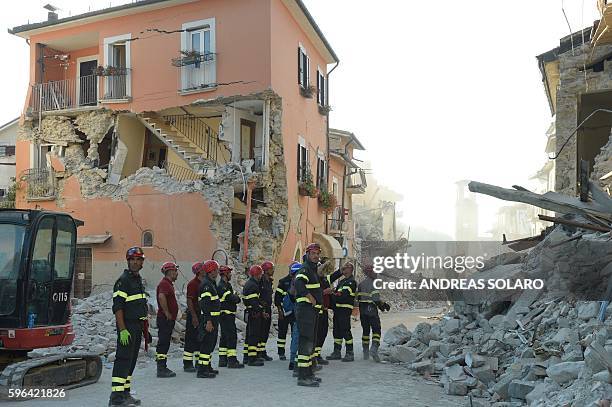 Firefighters inspect the rubble and debris in the damaged central Italian village of Amatrice on August 27 three days after a 6.2-magnitude...