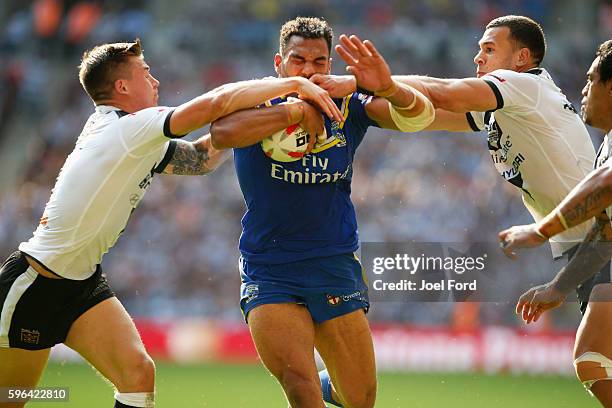 Ryan Atkins of the Warrington Wolves tries to break through a pair of tacklers during the Ladbrokes Challenge Cup Final between Hull FC and...