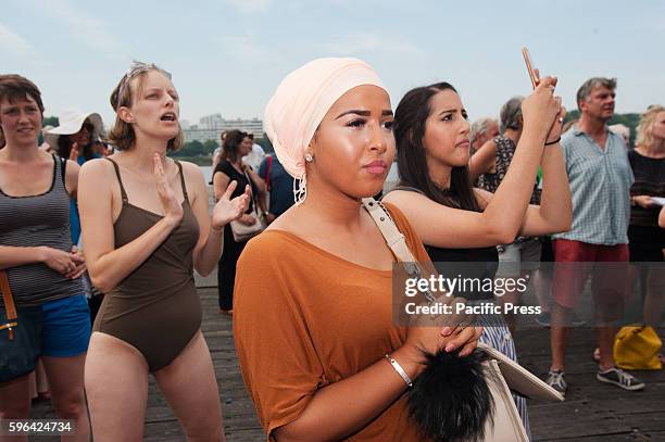 Woman in a head scarf listens to the speeches in Antwerp at the beach party protest against the ban of Burkini's in France.