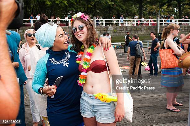 Woman in Burkini stands side tot side with a woman in Bikini in Antwerp at the beach party protest against the ban of Burkini's in France.