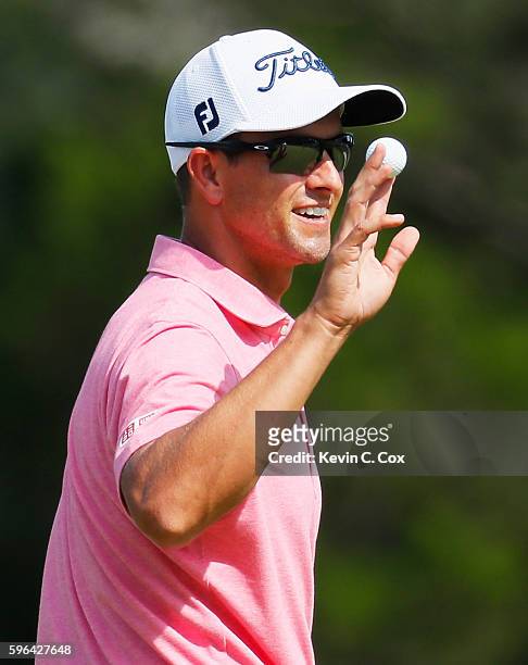 Adam Scott of Australia waves to the gallery on the 18th green after his six-under par 65 during the third round of The Barclays in the PGA Tour...