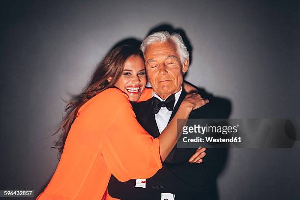young woman embracing elegant senior man - old man young woman stock pictures, royalty-free photos & images