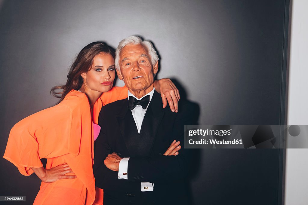 Young woman embracing elegant senior man