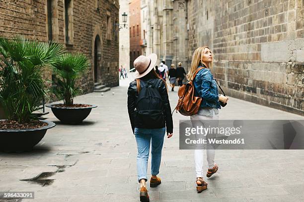 spain, barcelona, two young women walking in the city - europe city fotografías e imágenes de stock