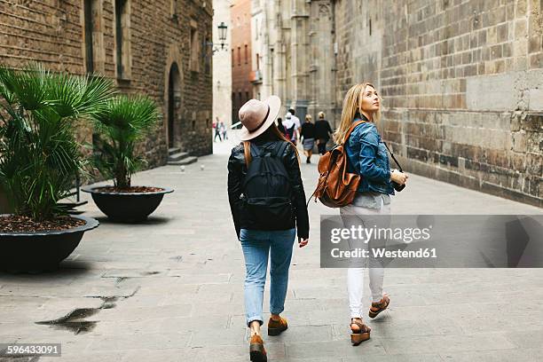spain, barcelona, two young women walking in the city - escapade urbaine photos et images de collection