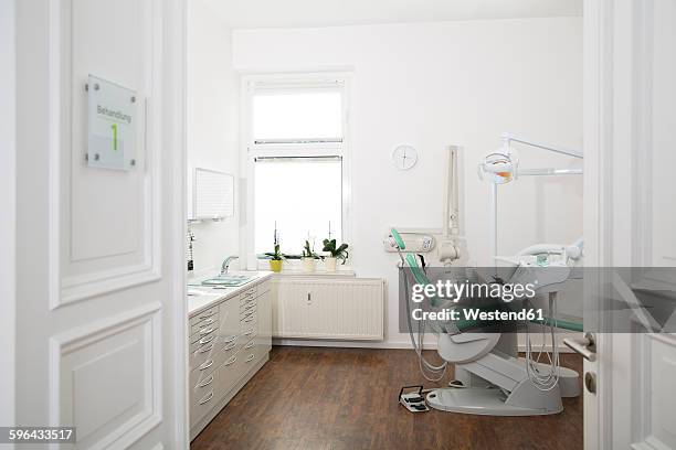 empty dental surgery - dentists chair stockfoto's en -beelden