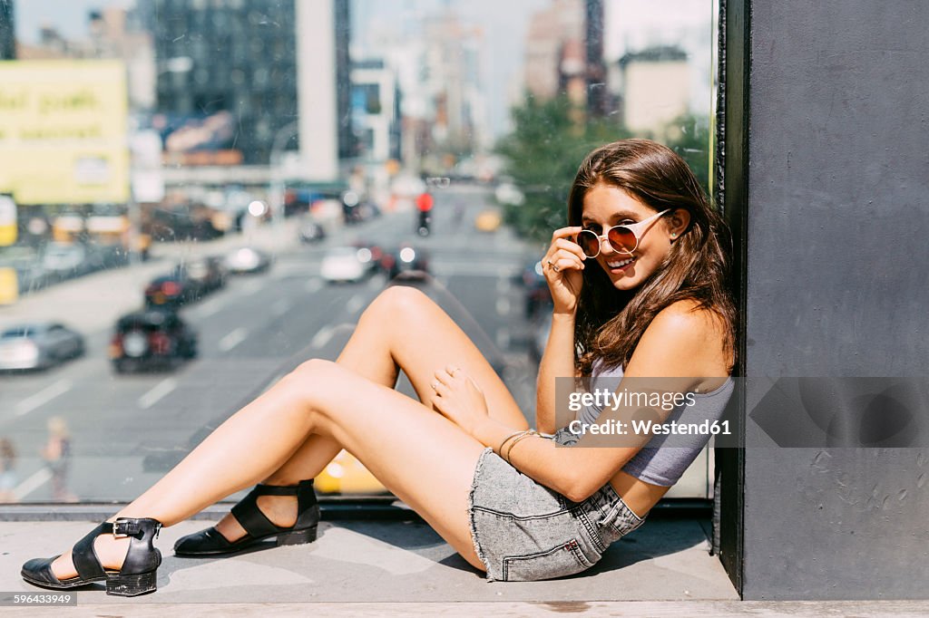 USA, New York City, smiling young woman relaxing in the city