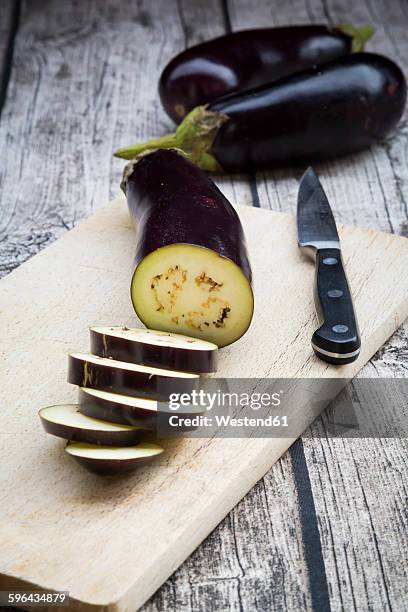 aubergines on chopping board, knife - aubergine stock pictures, royalty-free photos & images