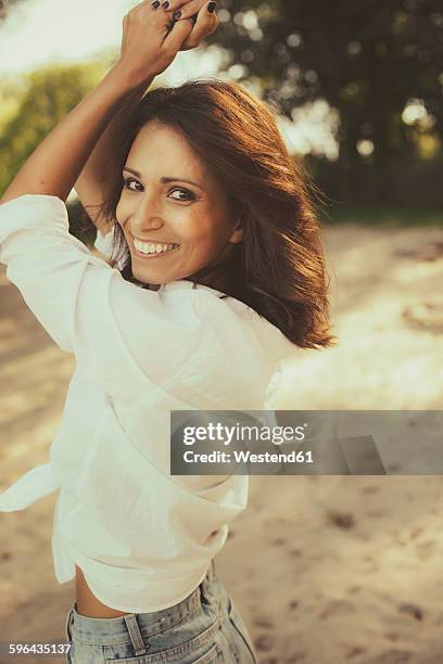 portrait of happy woman dancing on the beach - brown eyes stock pictures, royalty-free photos & images