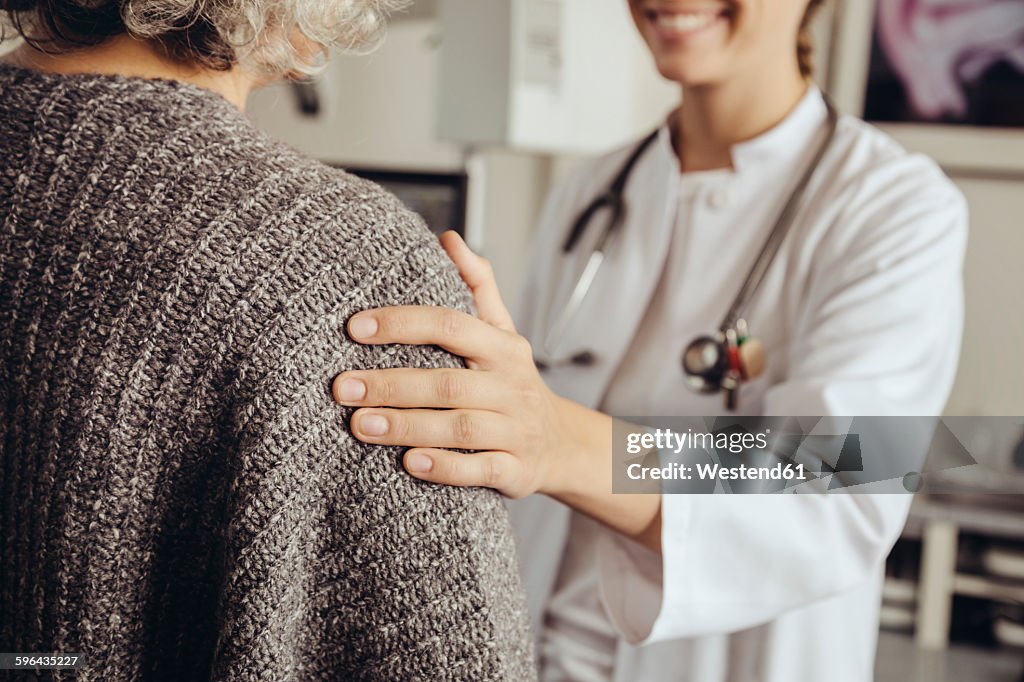 Doctor soothing senior patient