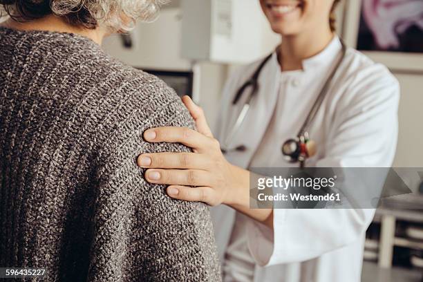 doctor soothing senior patient - hand på axel bildbanksfoton och bilder