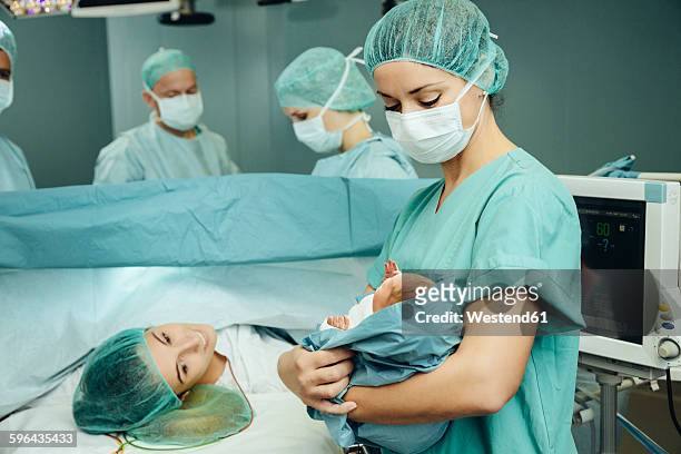 operating room nurse showing newborn to mother - delivery room stock pictures, royalty-free photos & images